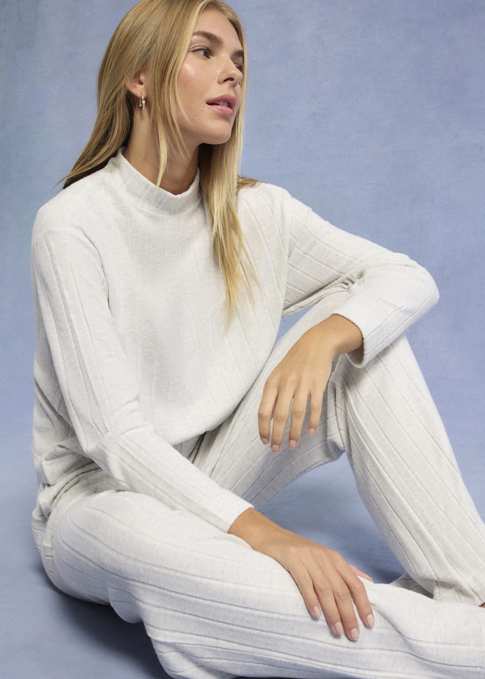 Elegantes weißes Ensemble: Gestrickter Pullover mit Stehkragen und passende Hose für einen zeitlosen Look.