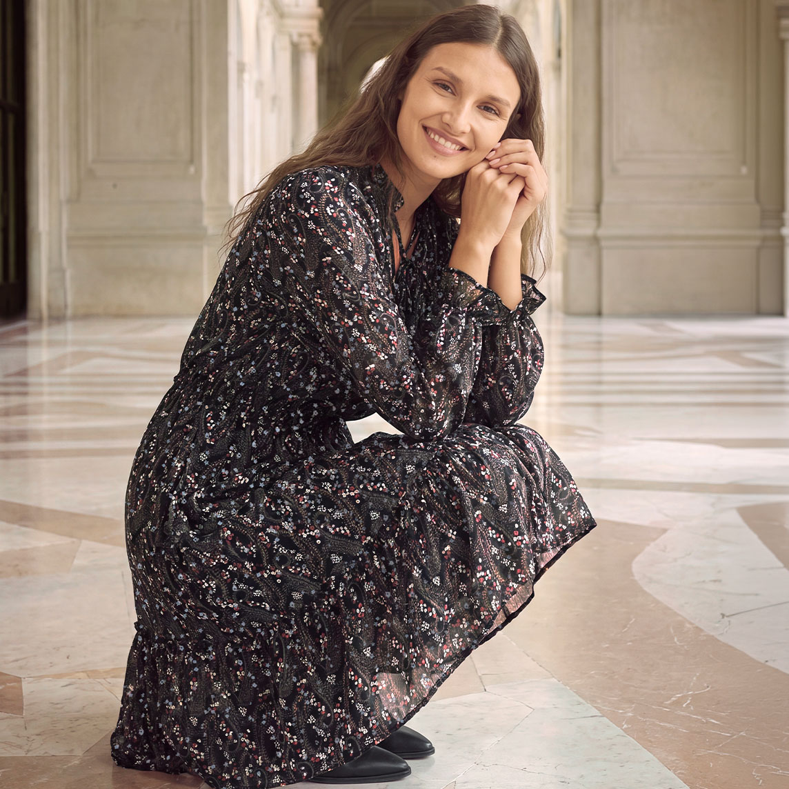 Ein stilvolles, gemustertes Kleid mit langen Ärmeln und eleganten schwarzen Schuhen.