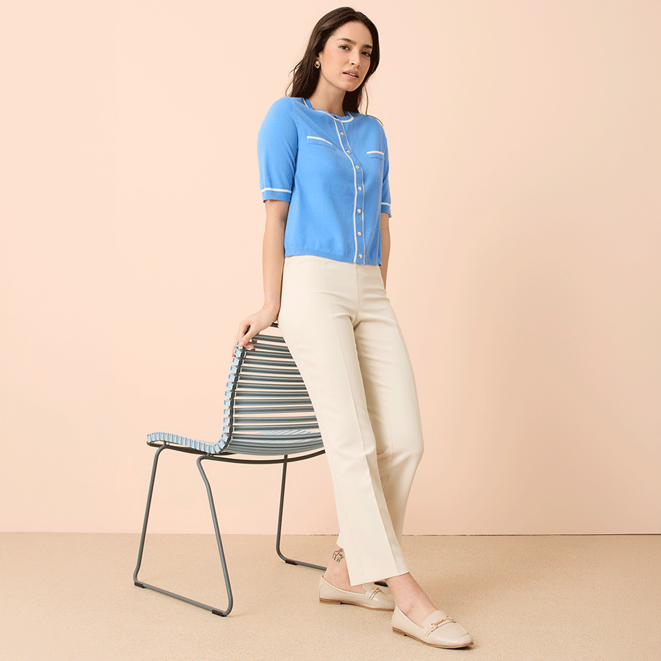 Hellblaue Kurzarm-Strickjacke kombiniert mit eleganter weißer Hose.