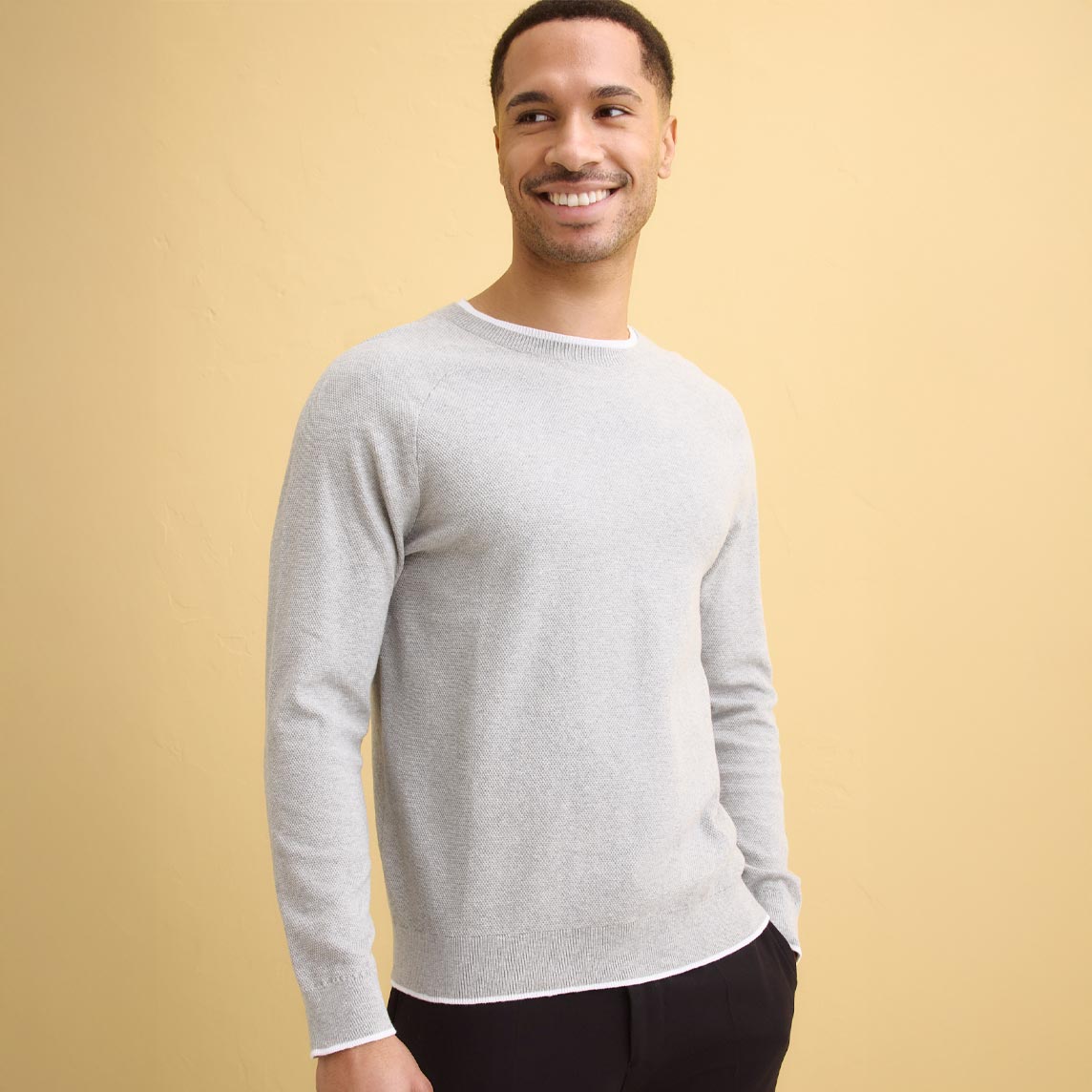 Hellgrauer Feinstrickpullover mit Rundhals-Ausschnitt.