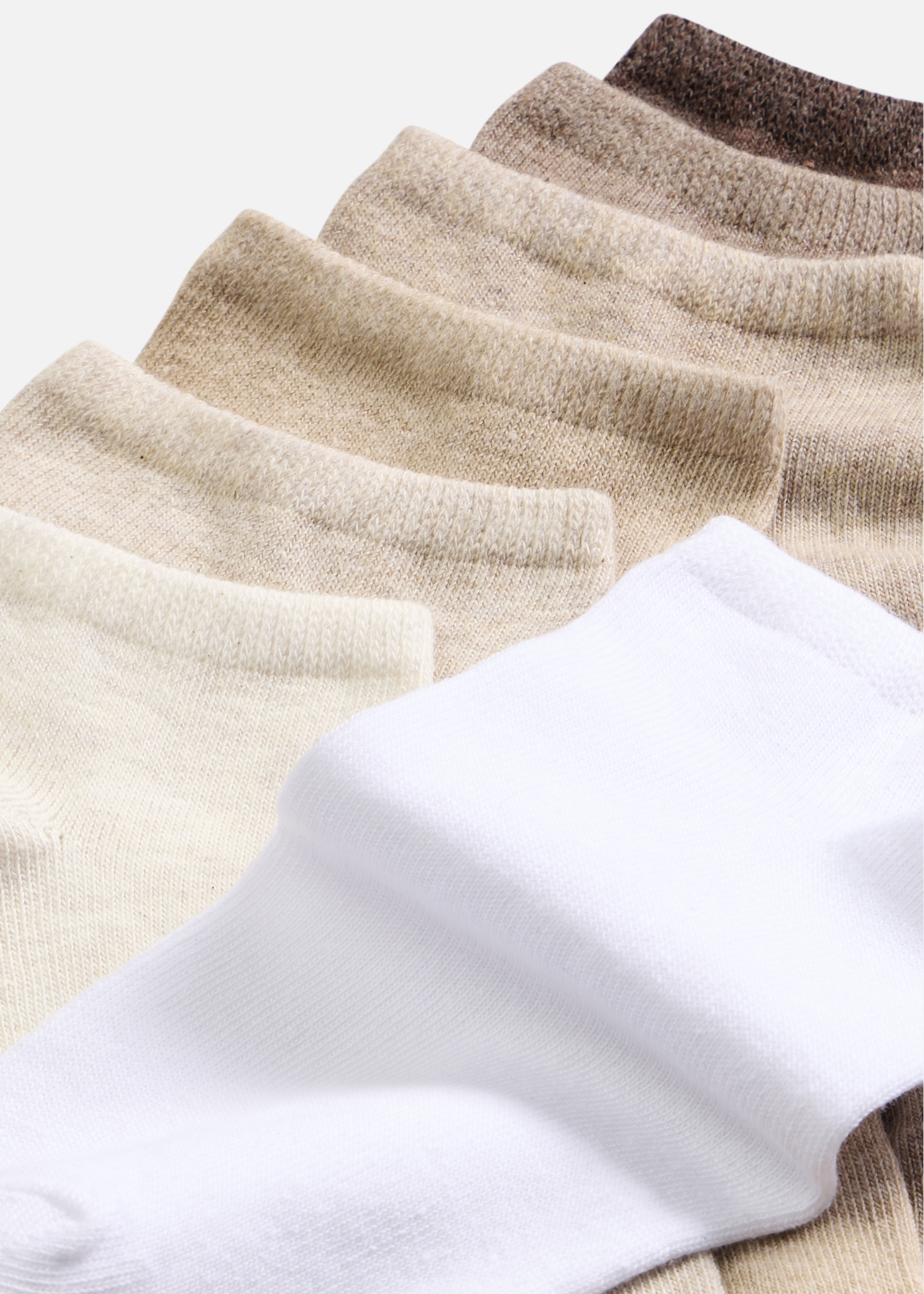 Eine Auswahl an gemütlichen Socken in abgestuften Erd- und Weißtönen.