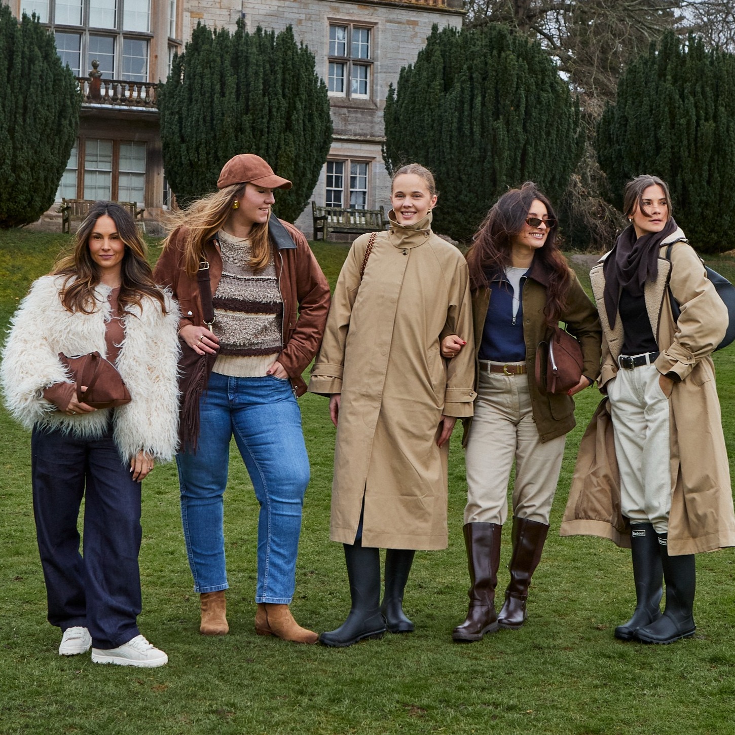 Strickpullover, Trenchcoat, Lederstiefel und Jeanshosen auf einem Gruppenbild.