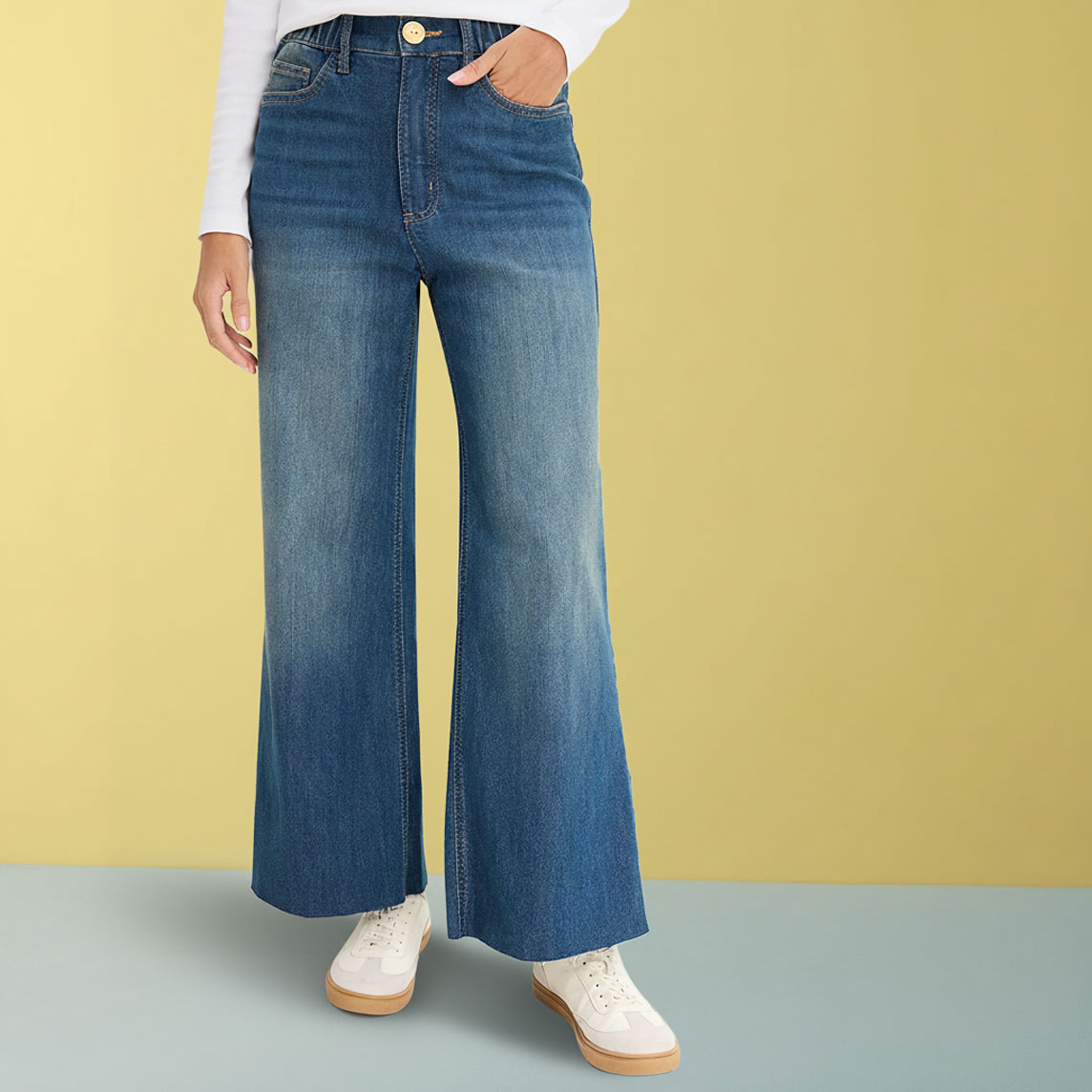 Weite Jeans mit weißem Oberteil und hellen Sneakers.