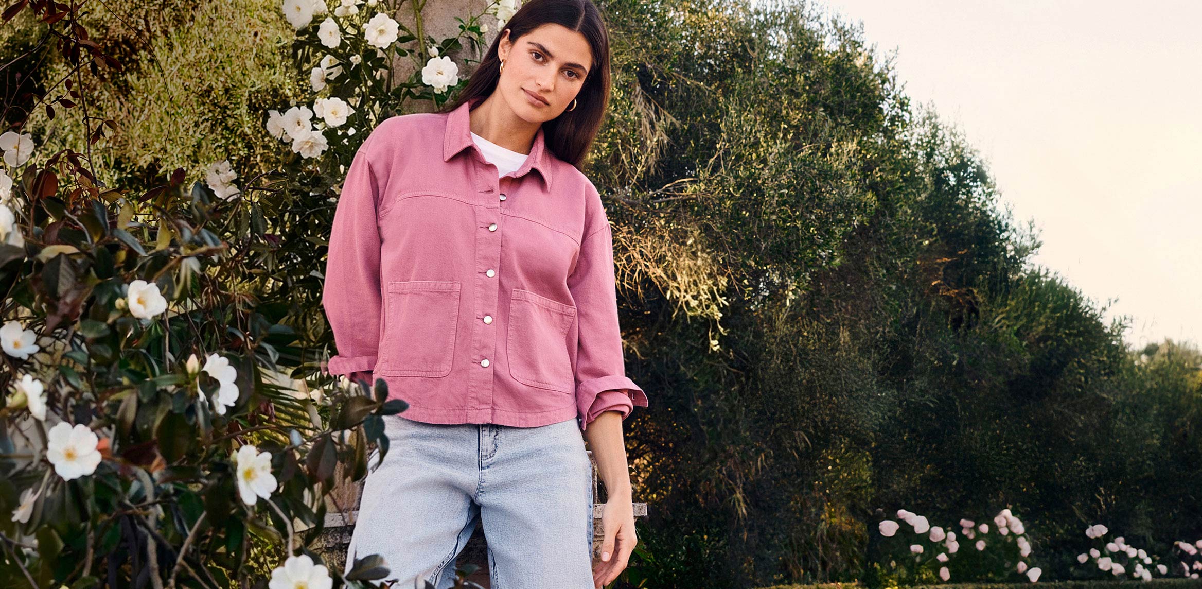 Rosa T-Shirt mit kurzen Ärmeln und Rundhalsausschnitt, kombiniert mit hellblauen Jeans.