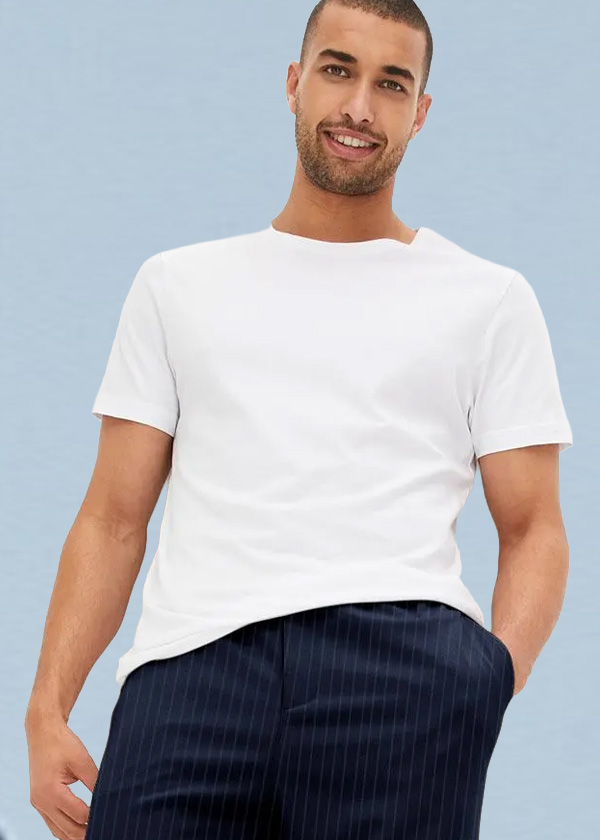 Er trägt ein weißes T-Shirt und eine dunkelblaue Hose mit feinen Streifen.