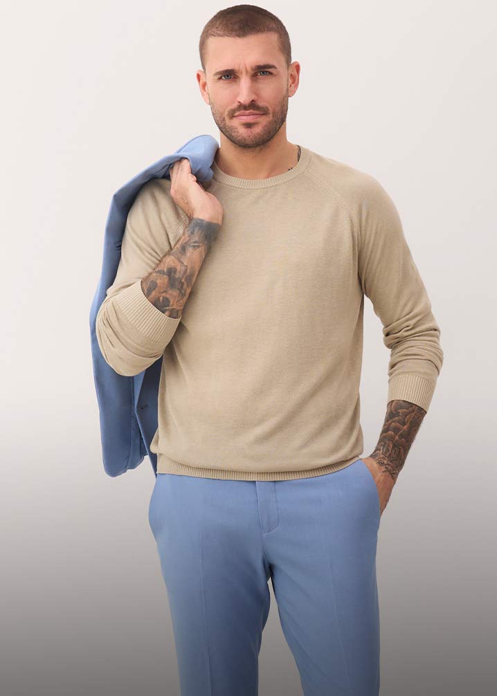Beiger Pullover, hellblaue Hose und blauer Blazer.