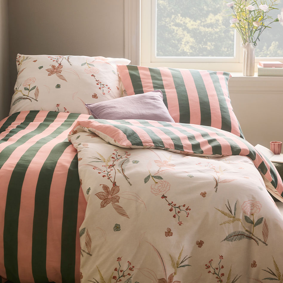 Bettwäsche mit zartem Blumenmuster und pastellfarbenen Streifen.