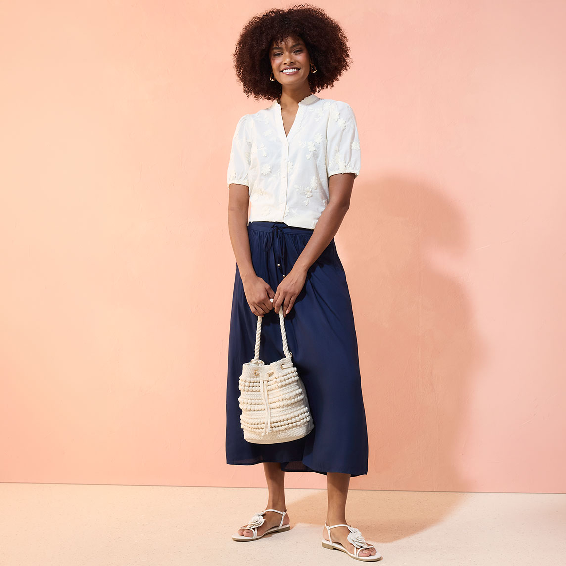Weiße Bluse und marineblaue Hose kreieren einen eleganten, lässigen Look.