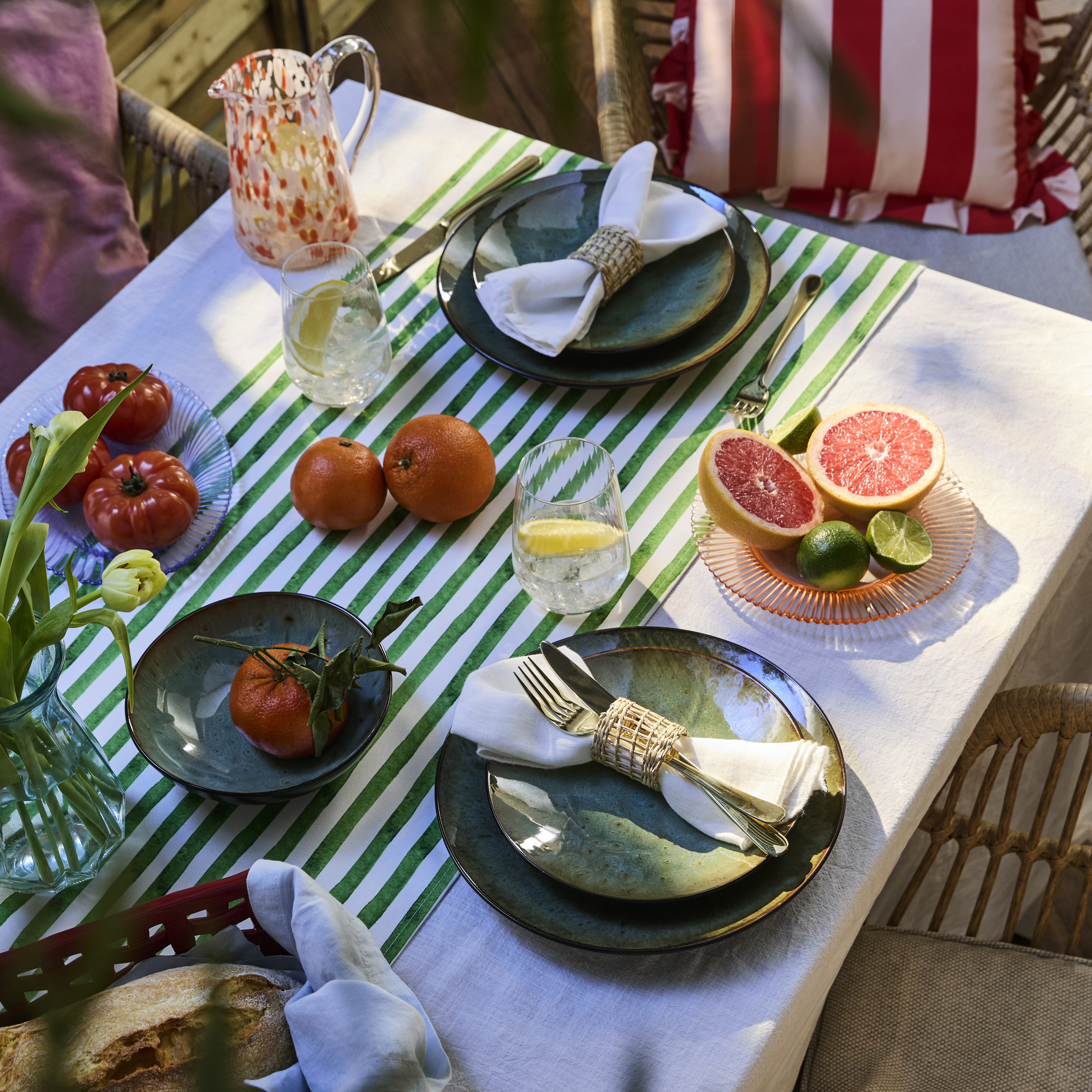 Gedeckter Tisch mit grünem Geschirr mit sommerlicher Atmosphäre.