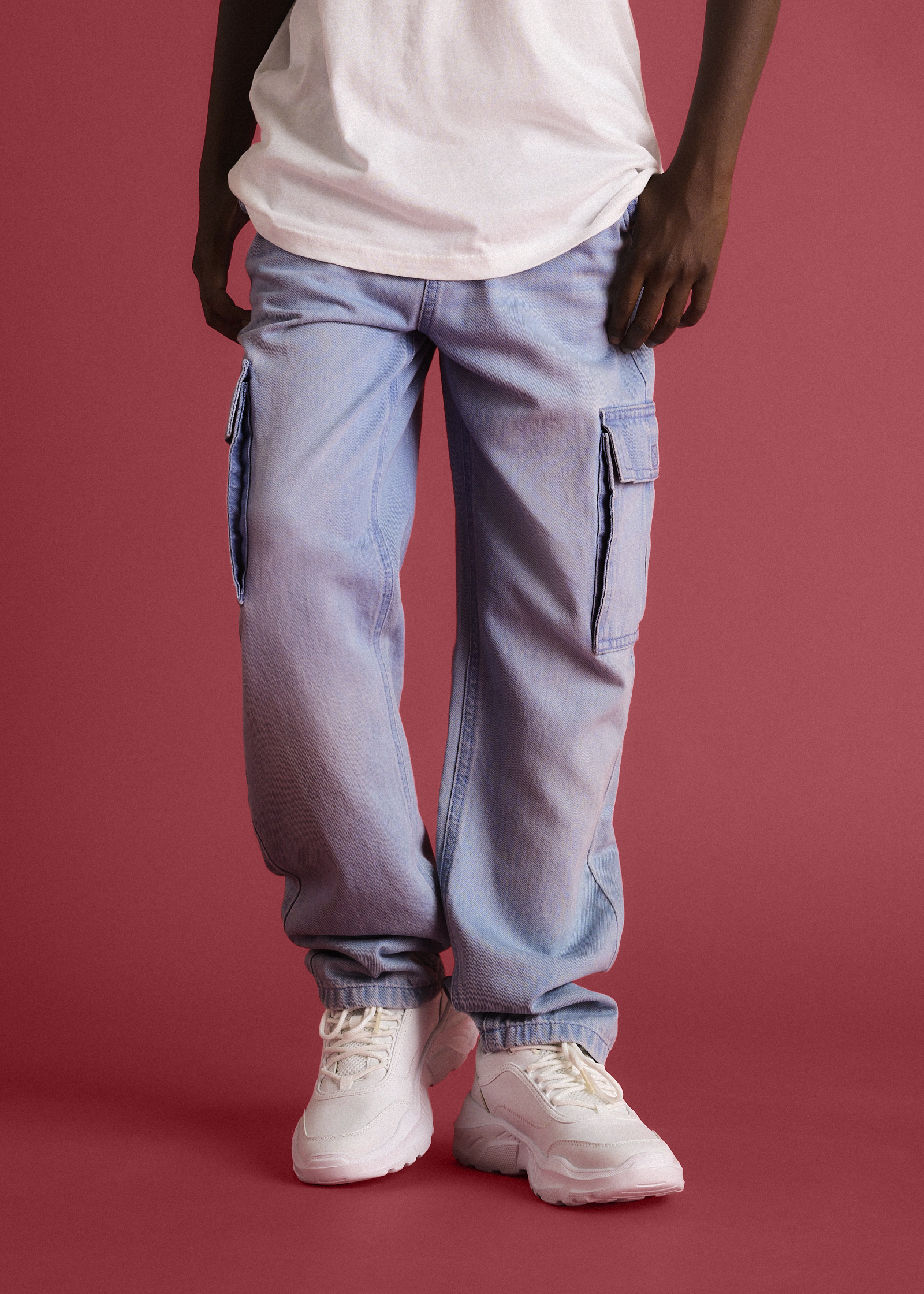 Grauer Hoodie, blaue Jeans und weiße Sneaker ergeben ein lässiges Outfit.