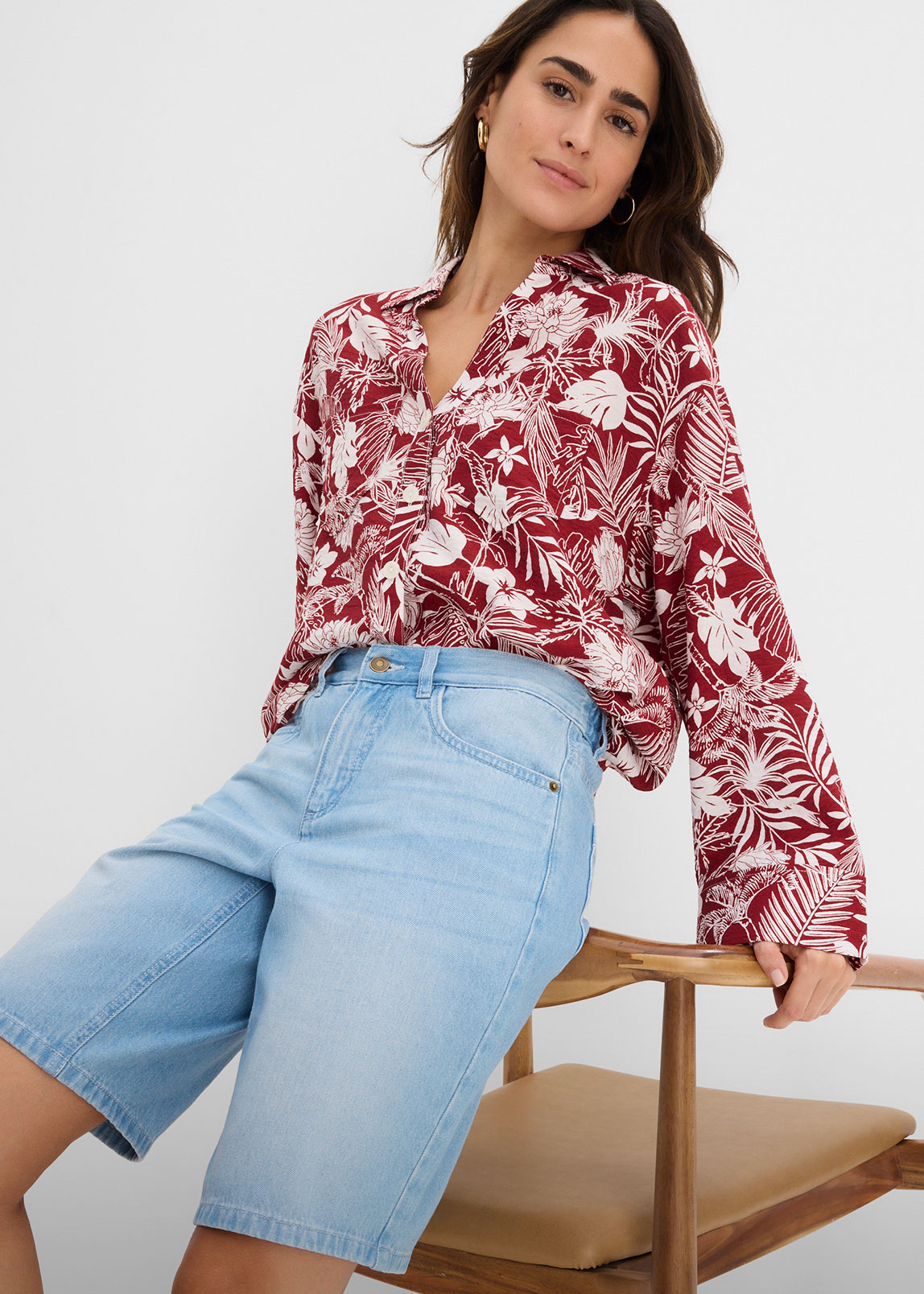 Rot-weiße gemusterte Bluse mit V-Ausschnitt und hellblaue Jeans-Shorts.