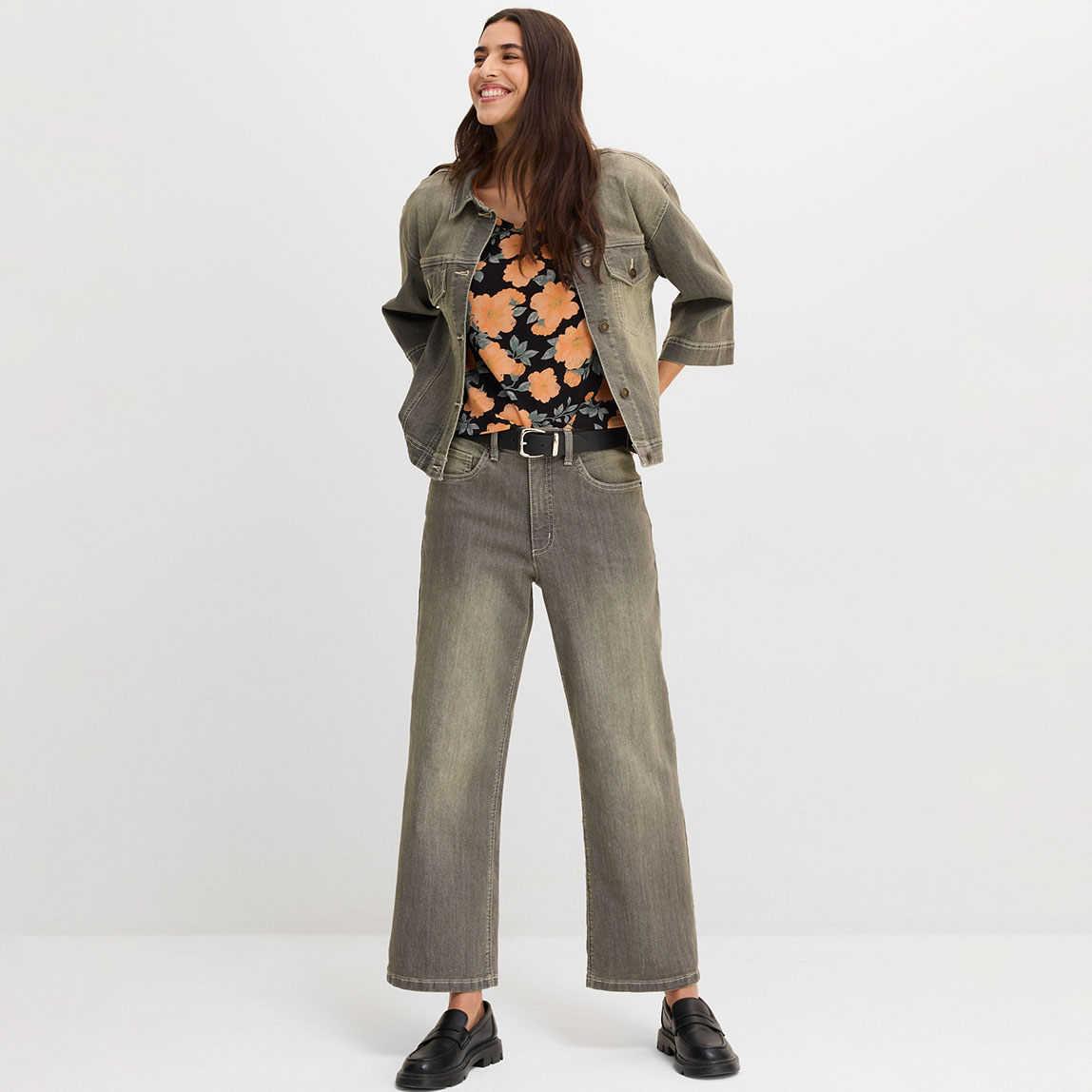 Graue weite Jeans, buntes Oberteil und oversized Jeansjacke.