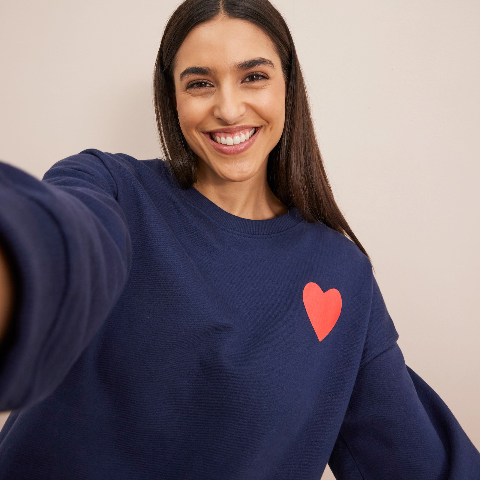 Dunkelblaues Sweatshirt mit rotem Herz-Motiv.