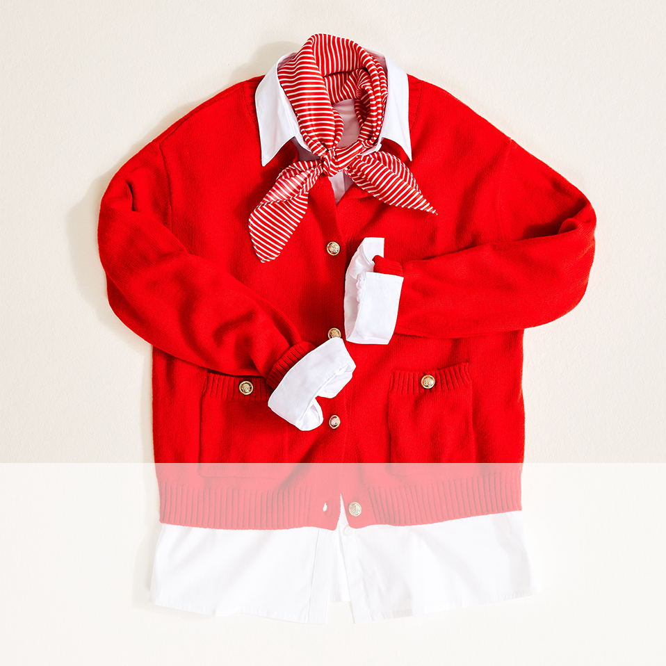 Leuchtend rote Strickjacke mit weißem Kragen, gestreiftem Halstuch und kleiner Tasche für Accessoires.