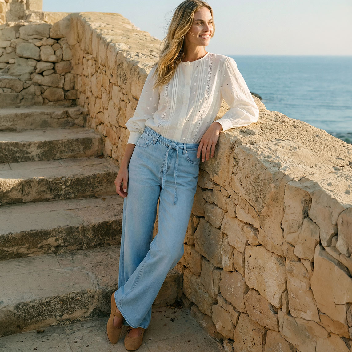 Luftige weiße Bluse kombiniert zur hellblauen Jeans.