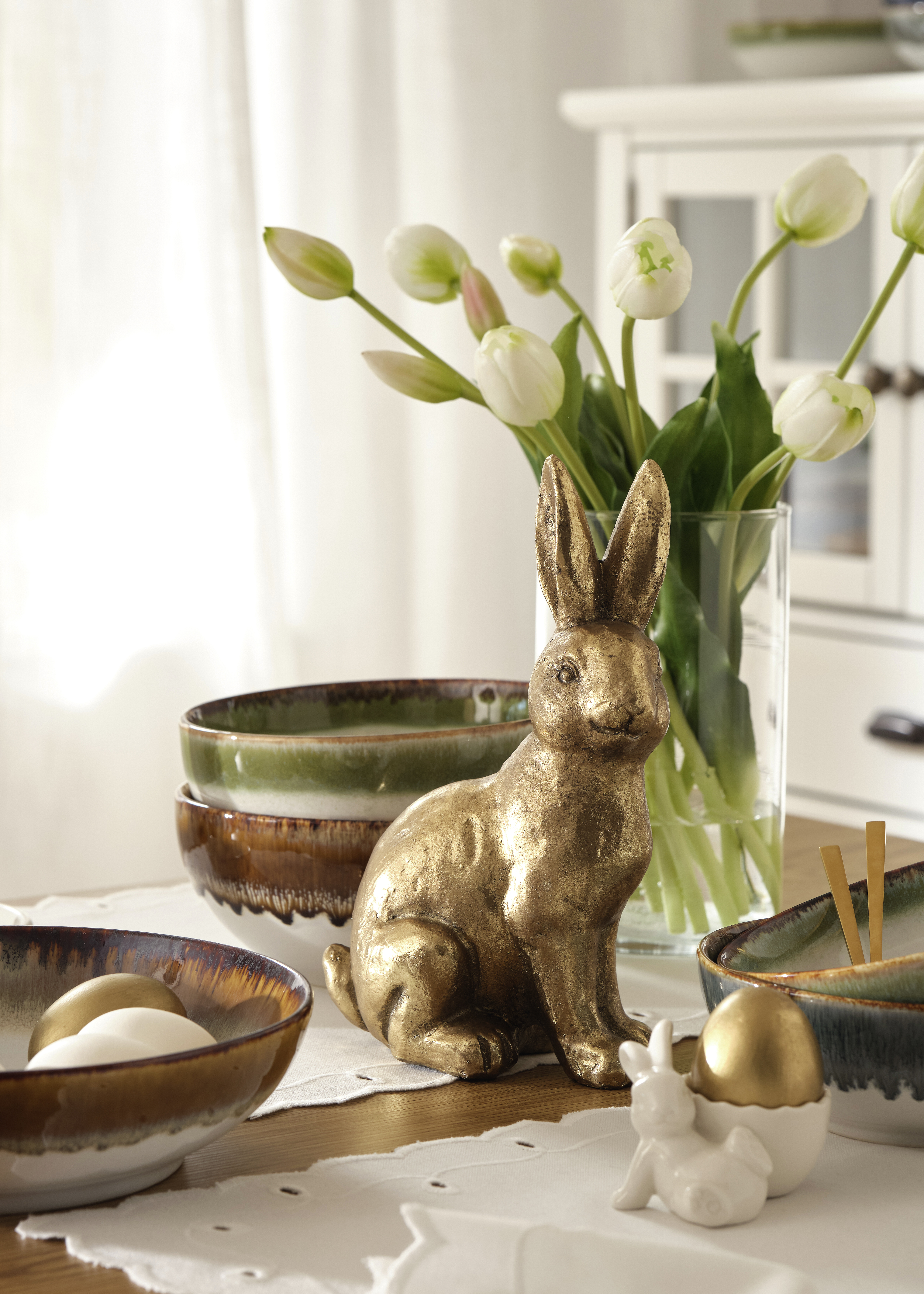 Osterdekoration mit goldener Hasenfigur.