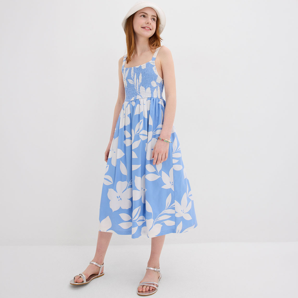 Luftiges blaues Sommerkleid mit weißem Blumenmuster und Trägern, perfekt für warme Tage.
