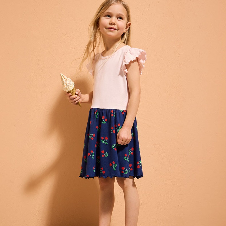 T-Shirt mit Rüschen und dunkelblauen Rock mit bunten Blumenmustern.