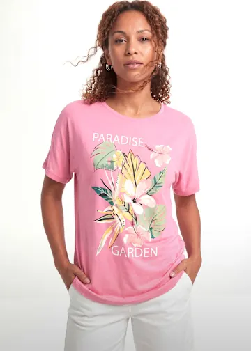 Rosa T-Shirt mit Blumenmotiv und weiße Hose.