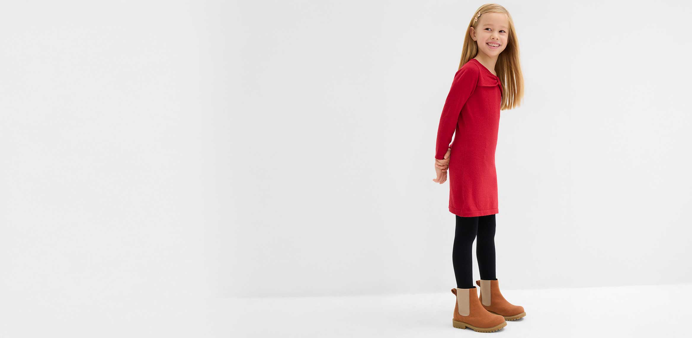 Kleines Mädchen trägt ein rotes Strickkleid.