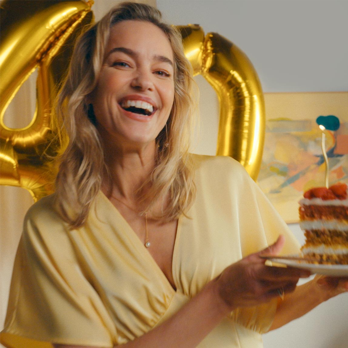 Eine Frau mit Torte und Luftballons zum 40. Geburtstag der Marke bonprix 