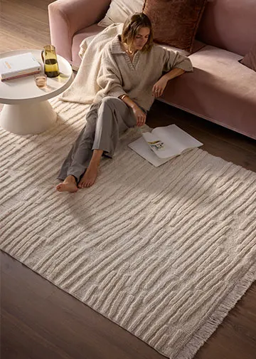 Stilvoller Raum mit kariertem Teppich, gemütlichem Sessel und minimalistischem Beistelltisch.