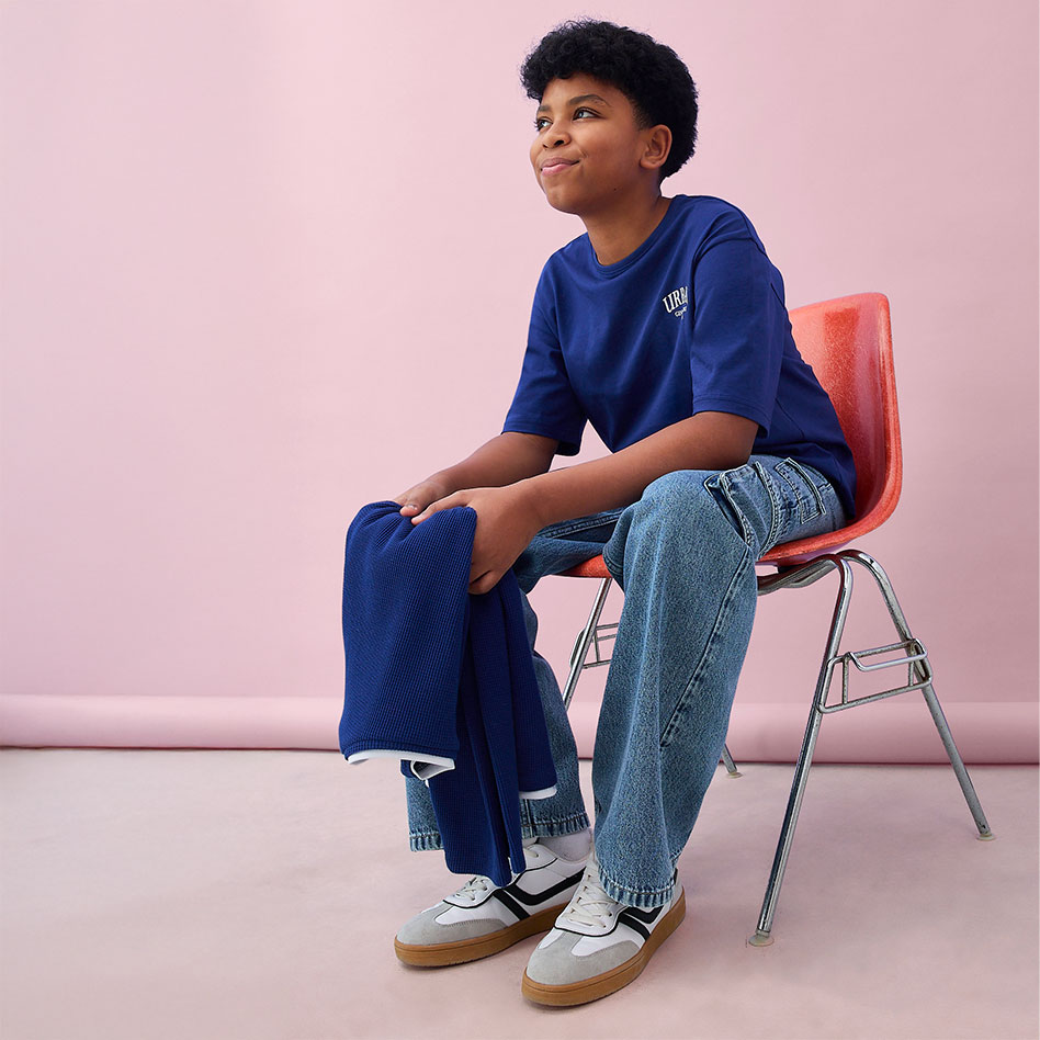 Lässiger Look: Blaues T-Shirt, helle Jeans und bequeme Sneakers. Stilvolle Kombination für den Alltag.