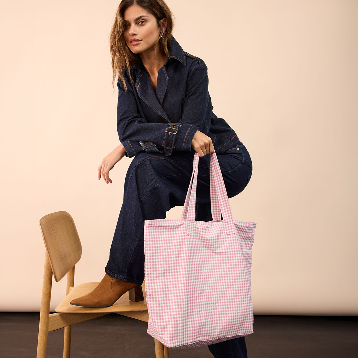 Jeansoutfit, kombiniert mit braunen Schuhen und karierter rosa Tasche.