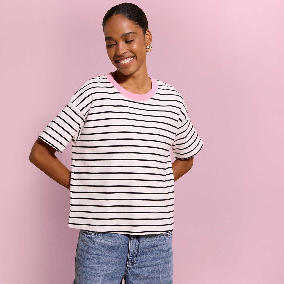 Lässiges, gestreiftes T-Shirt mit rosa Kragen und blaue Jeans.