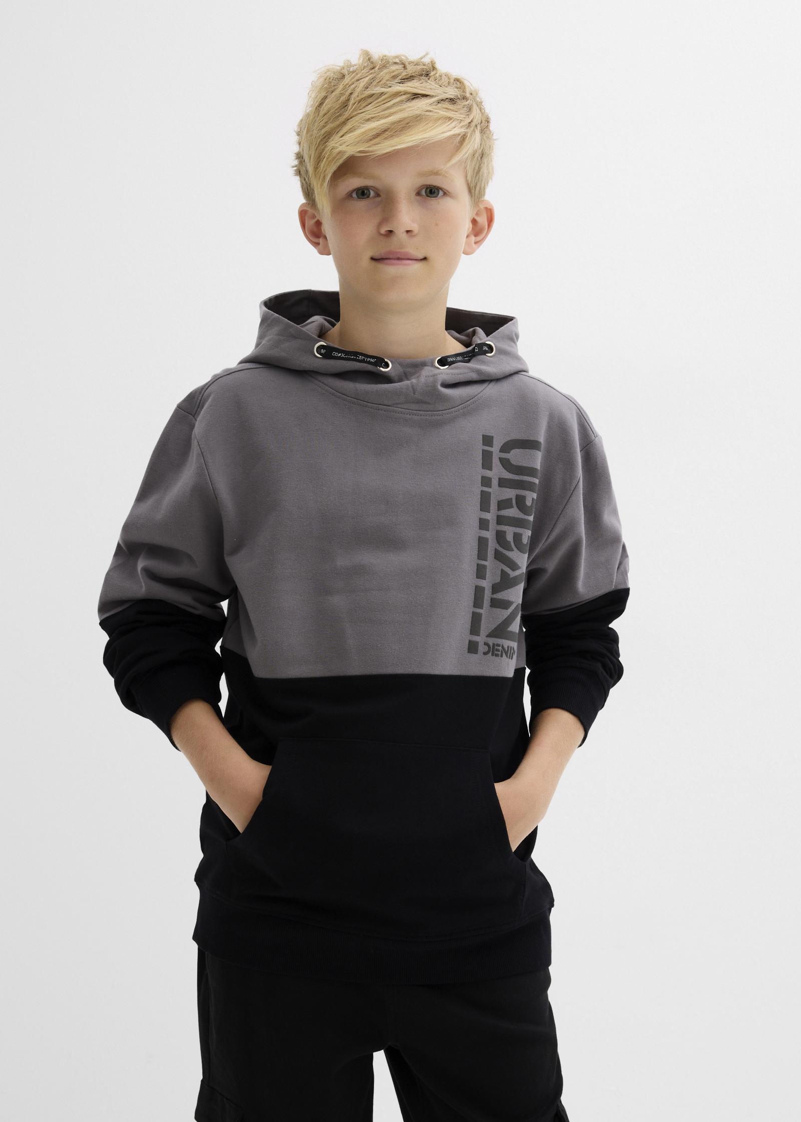 Zweifarbiger Hoodie in Grau und Schwarz mit "URBAN" Aufdruck, dazu schwarze Hose.