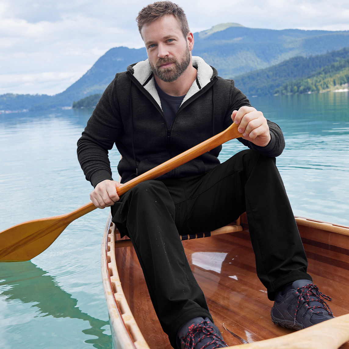 Schwarze Thermo-Sweatjacke und dunkle Hose. 