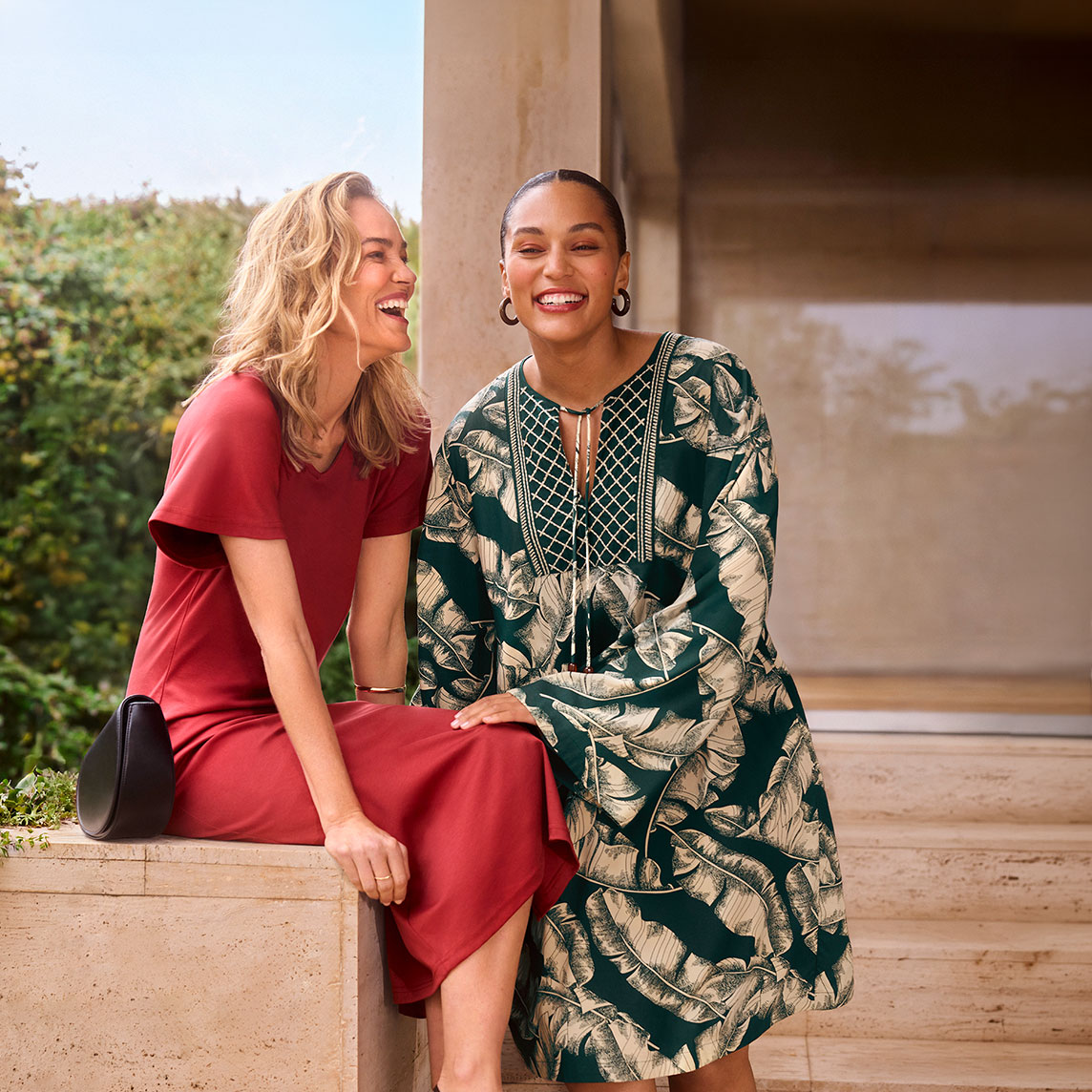 Zwei Frauen in eleganten Kleidern: rotes Kleid und grünes Blattmuster-Kleid mit Stickerei.