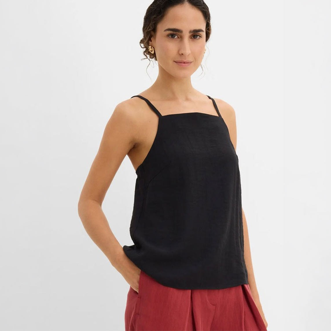 Schwarzes Top kombiniert mit einer roten weiten Hose für einen lässigen Look.