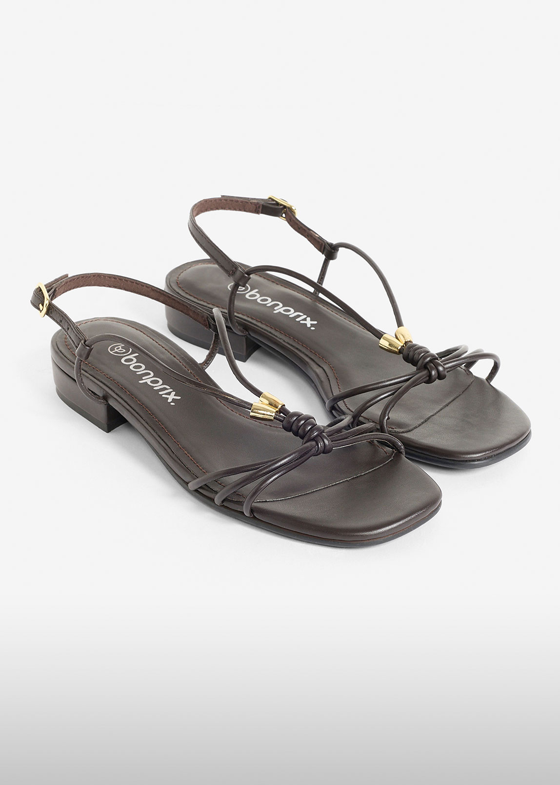 Braune Riemchensandalen mit feinen Bändern und eleganten goldenen Details, perfekt für warme Tage.