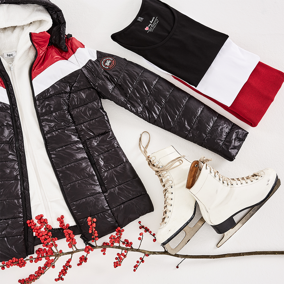 Winteroutfit: Gesteppte Jacke, kuschelige Accessoires und elegante Schlittschuhe für festliche Stimmung.