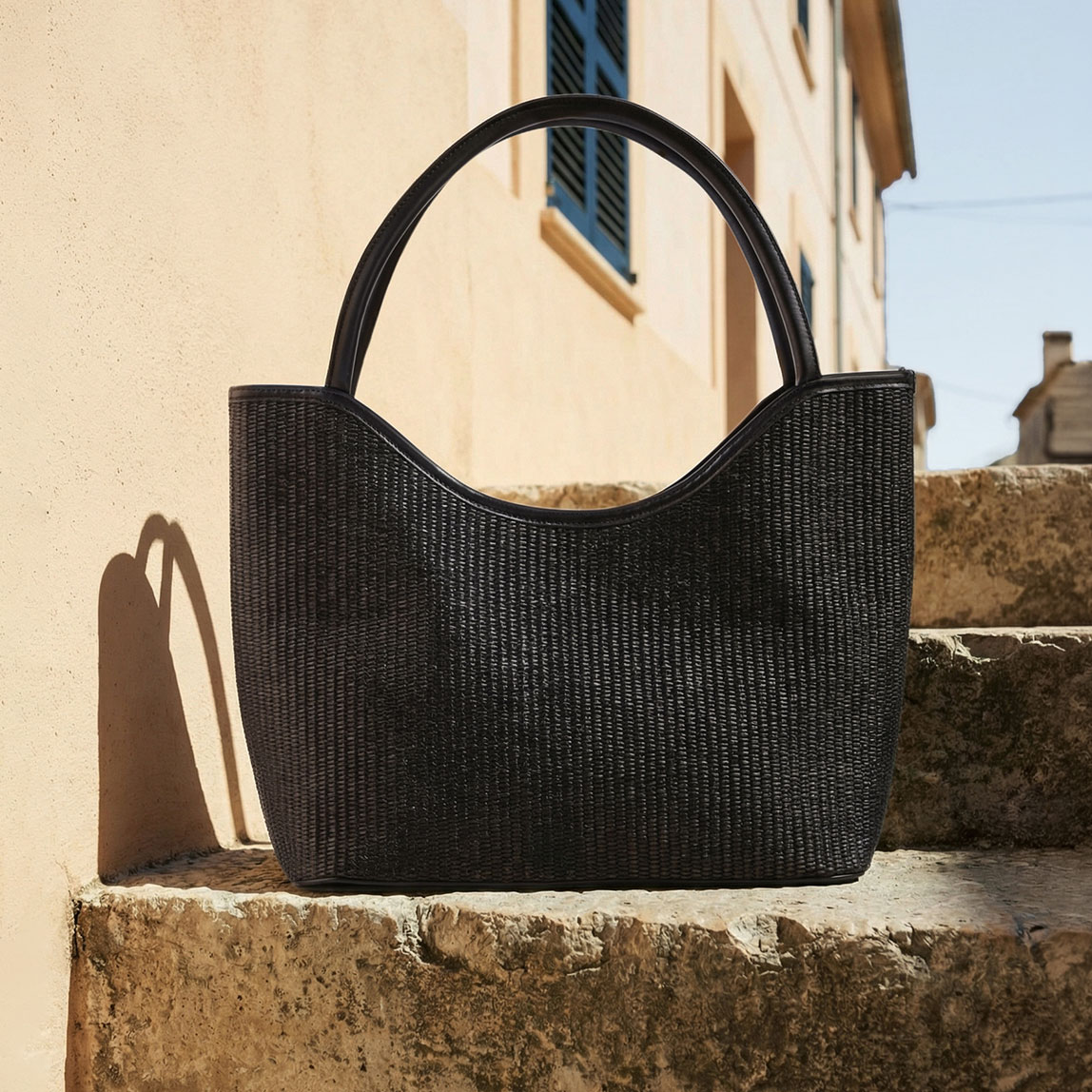 Schwarze Tasche aus geflochtenem Material.