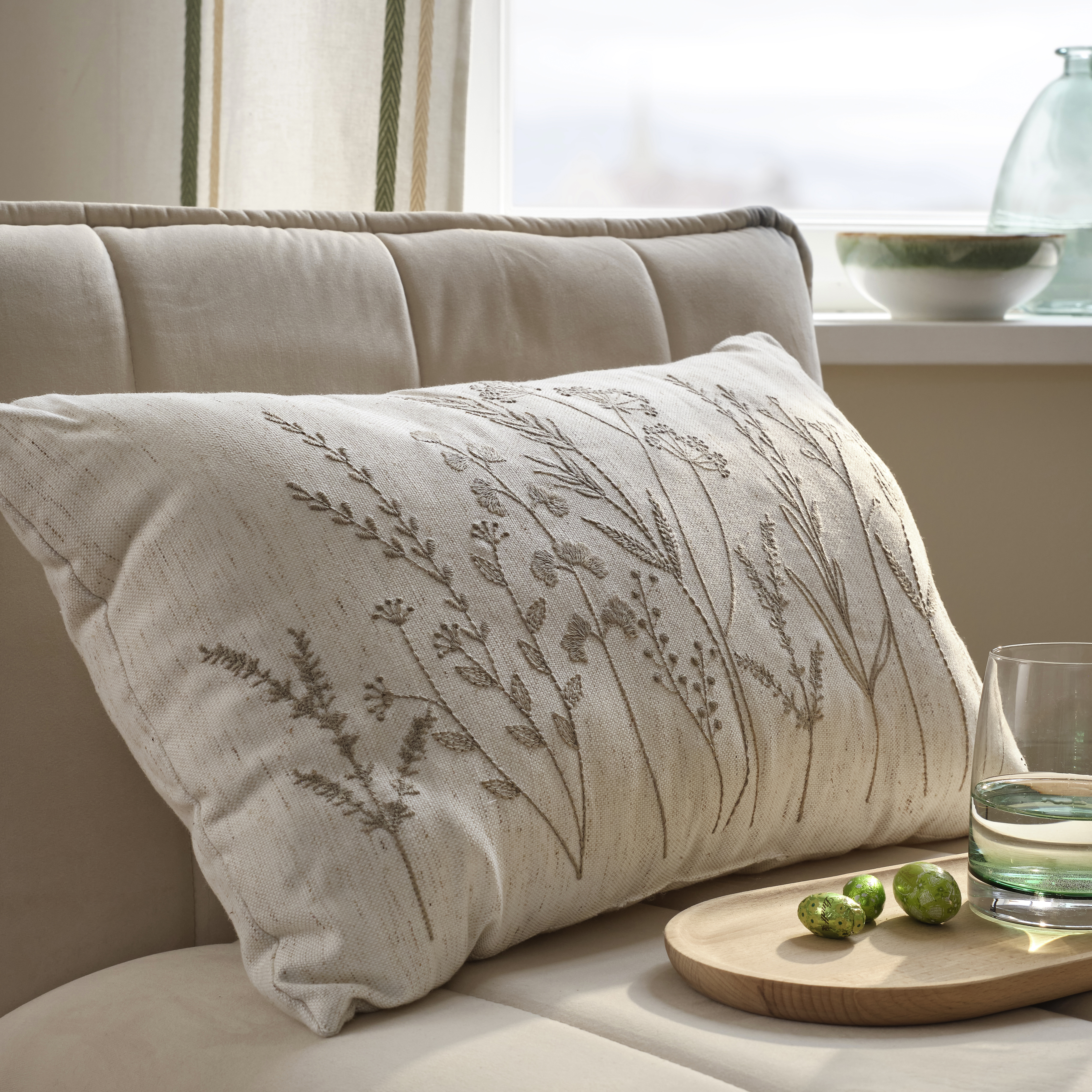 Elegantes Kissen mit filigraner Stickerei.