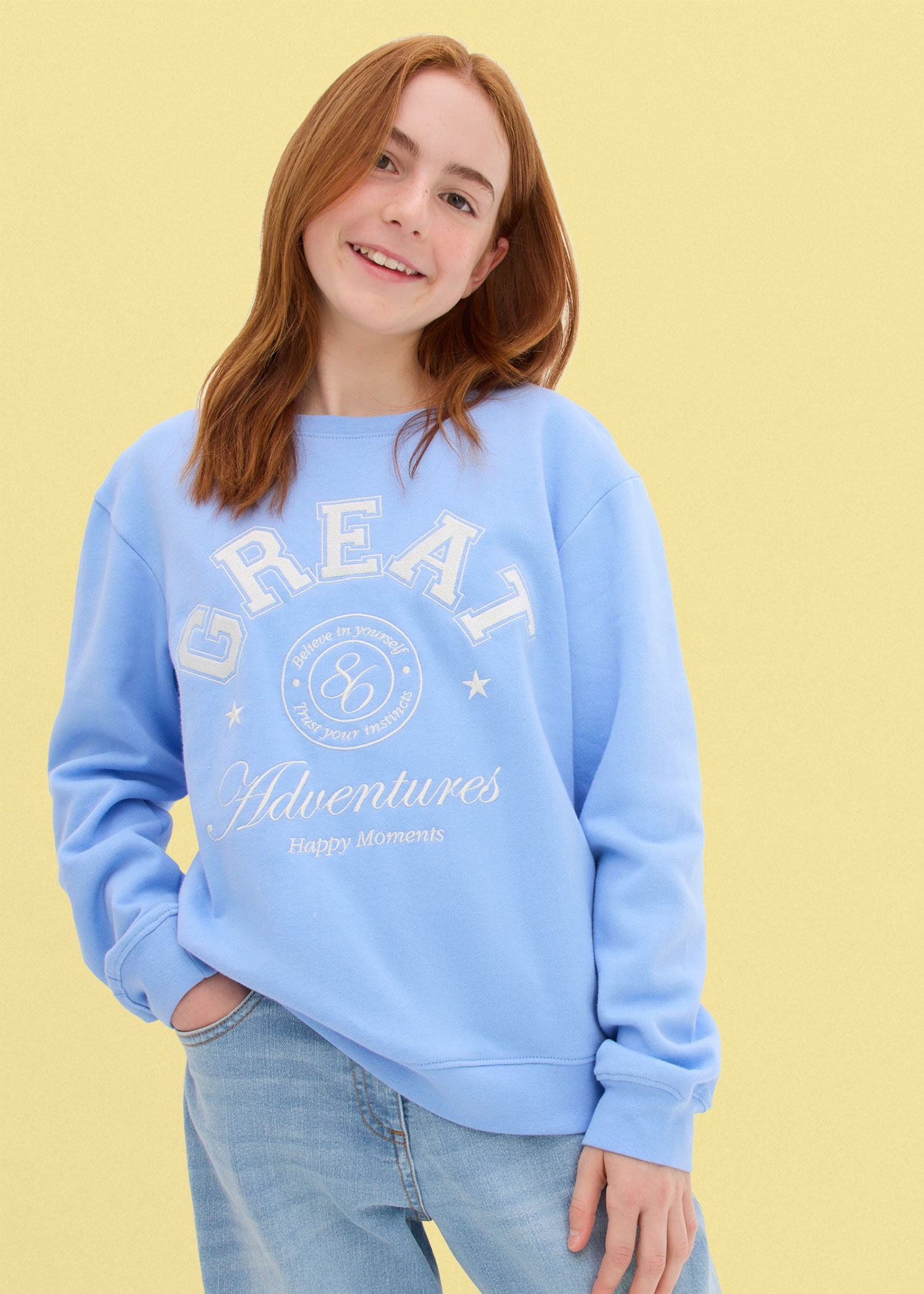 Hellblauer Sweatshirt mit Schriftzug und bequemen Jeans.