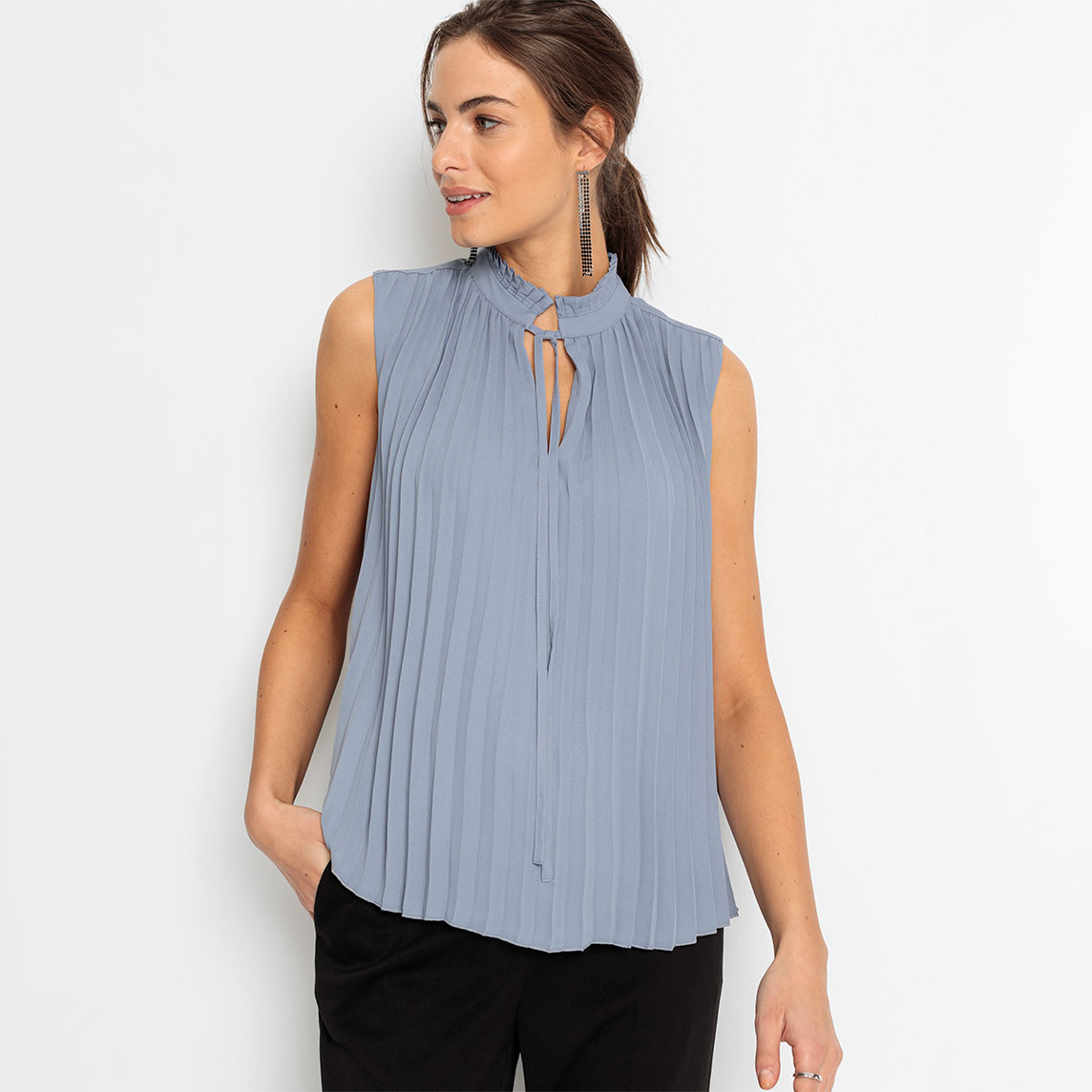 Elegante, plissierte hellblaue Bluse mit Stehkragen und Kordelzug, dazu schwarze Hose.