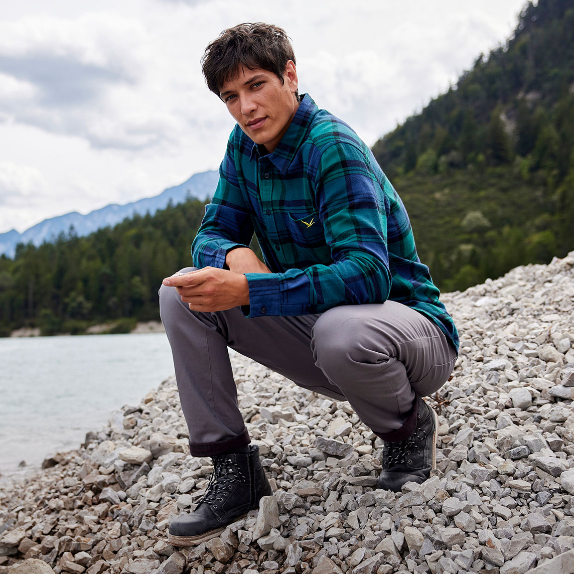 Ein kariertes Flanellhemd, graue Thermo-Hose und robuste Wanderschuhe.