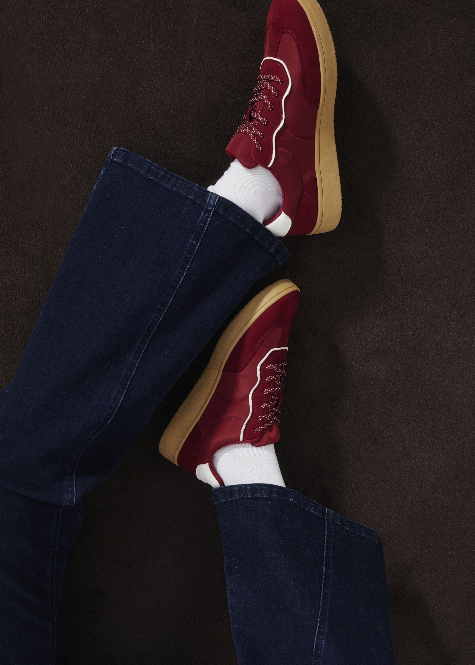 Stylische rote Sneaker, weiße Socken und blaue Jeans.