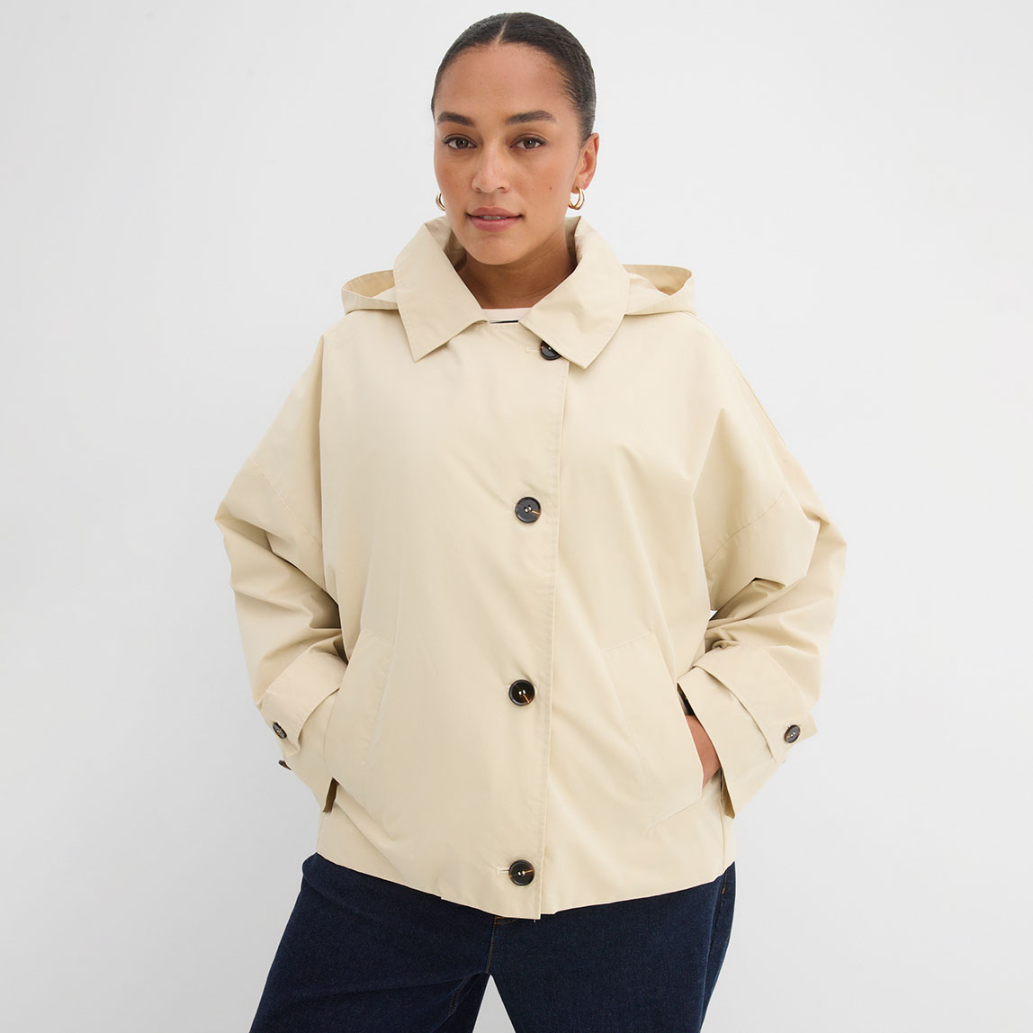 Cremefarbene Jacke mit Knöpfen und Kragen.