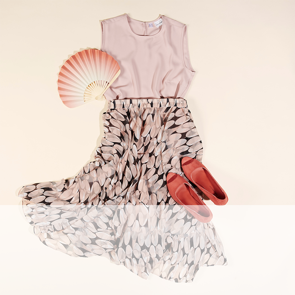 Sommerliches Outfit: Zartes Top, luftiger Rock mit Muster, rote Sandalen und eleganter Fächer.