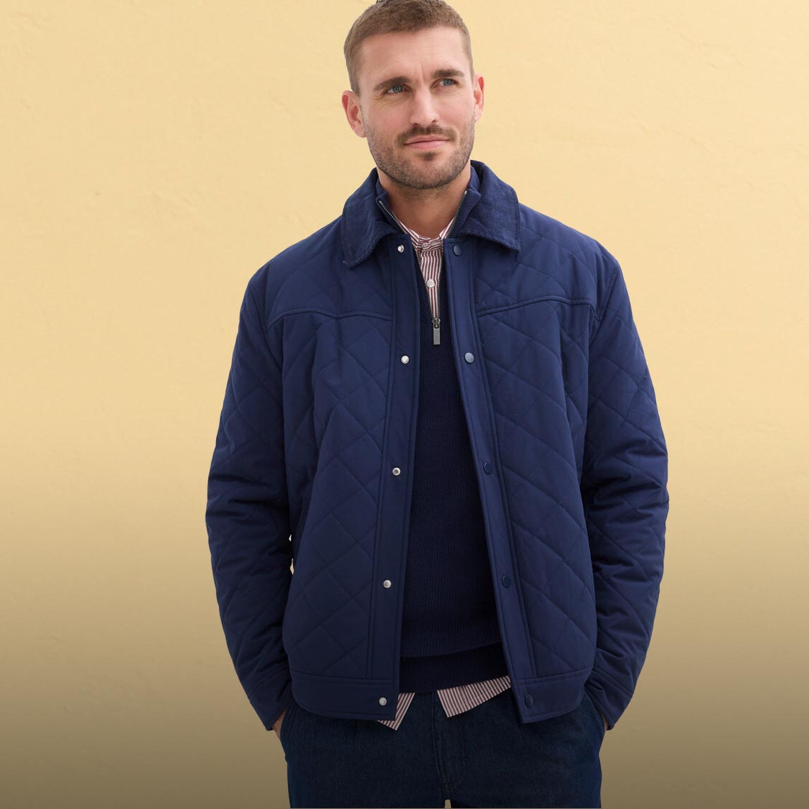 Blau-graue Steppjacke, helles T-Shirt, Jeans und weißer Baseballkappe.