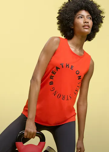 Rotes Tanktop mit "Breathe On Stay Strong" und dunkle Leggings für das Training.