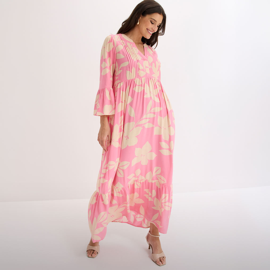 Pinkes Maxikleid mit floralem Muster, V-Ausschnitt und eleganten Glockenärmeln.