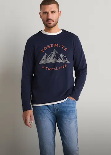 Mann trägt Jeans und ein dunkelblaues Langarmshirt mit Yosemite National Park-Aufdruck.