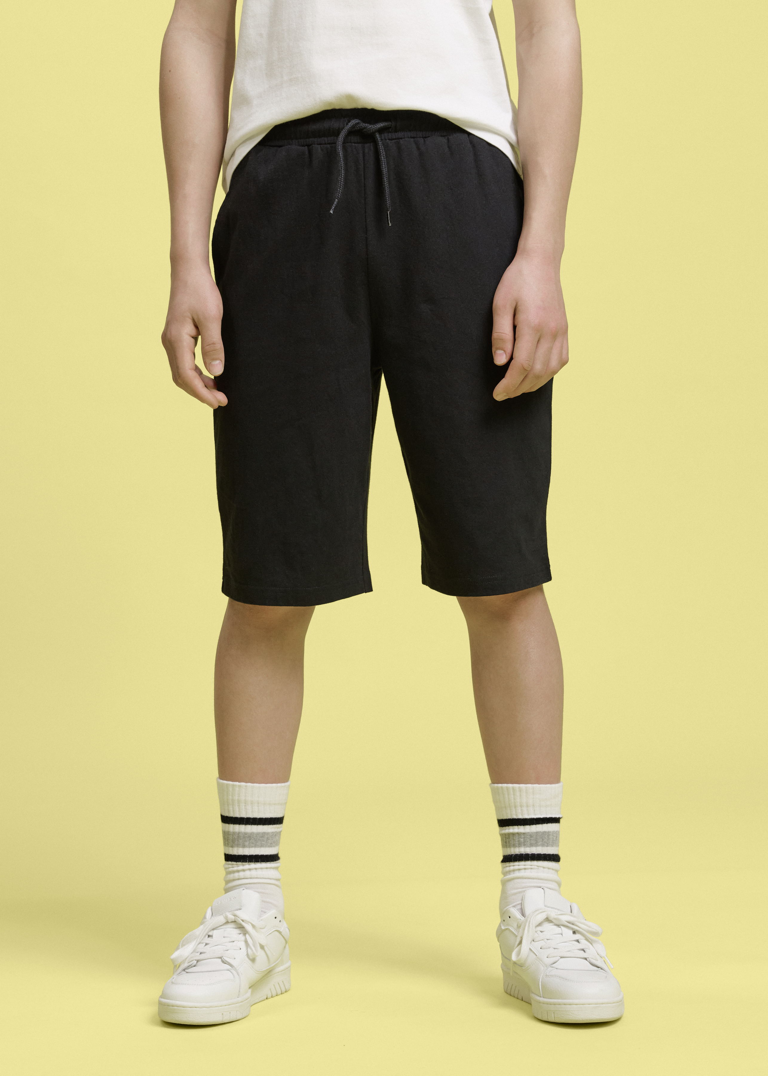 Outfit mit weißem Shirt und schwarzen Shorts.