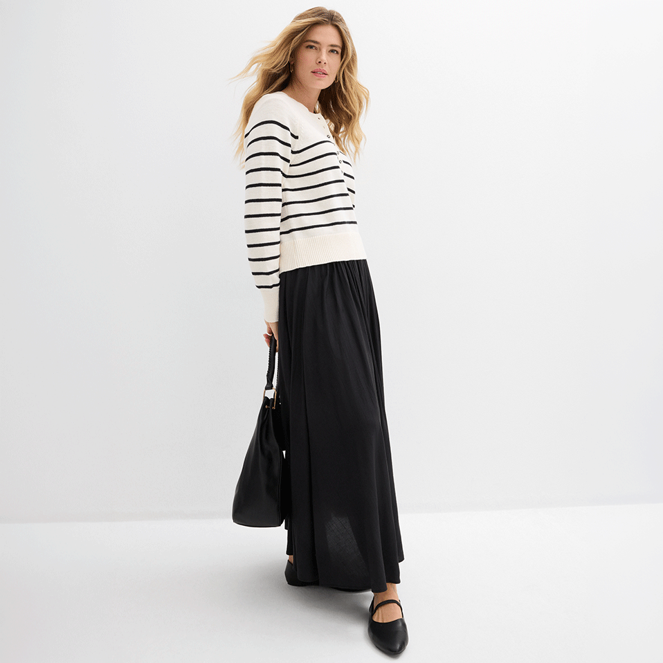 Gestreifter Pullover trifft auf langen schwarzen Rock. 