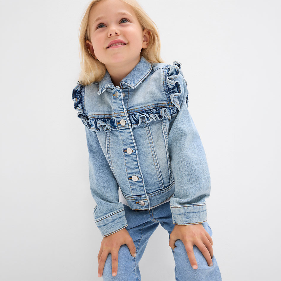Hellblaue Jeansjacke mit Rüschen-Details am Kragen und Schulterbereich.